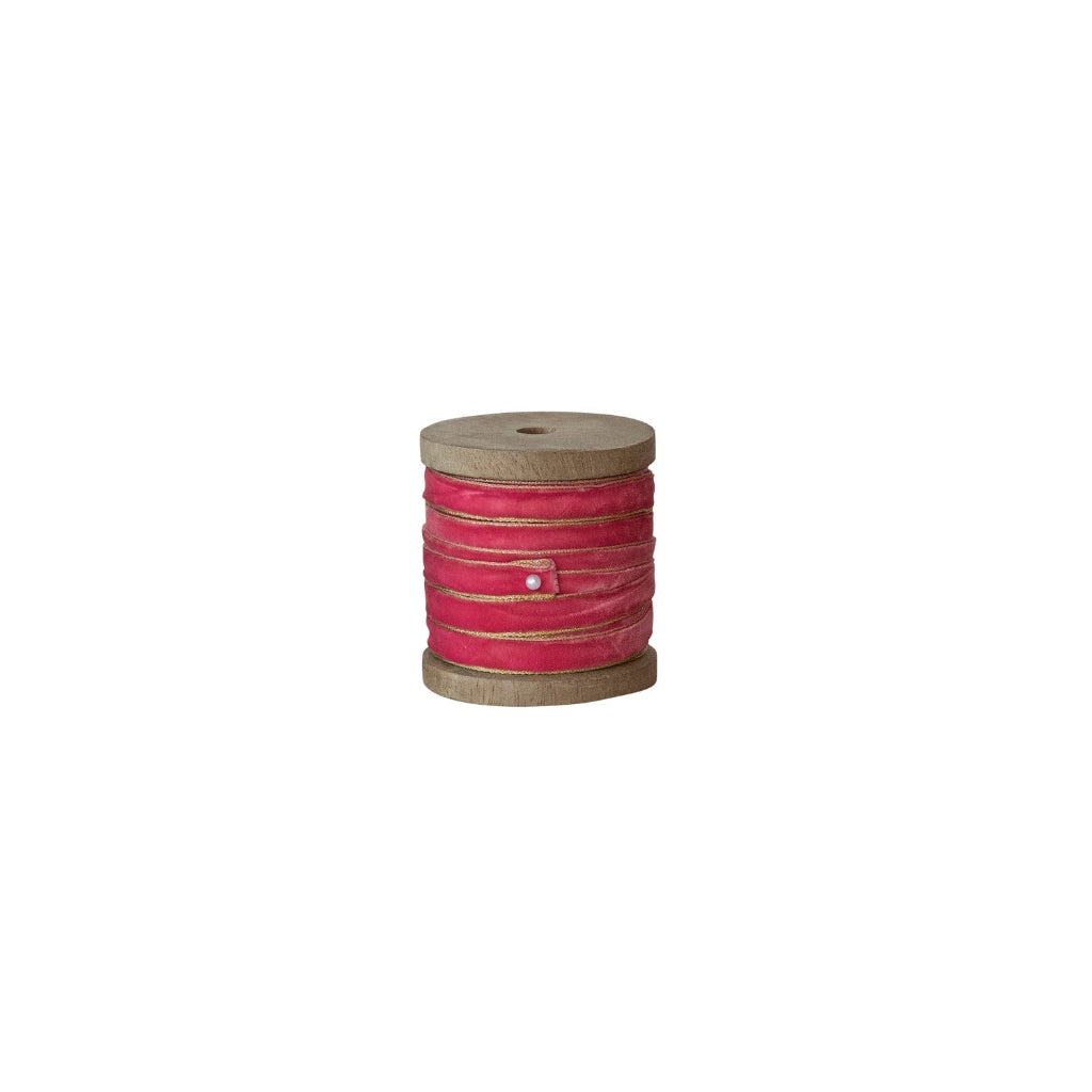 pink ribbon on a wood spool