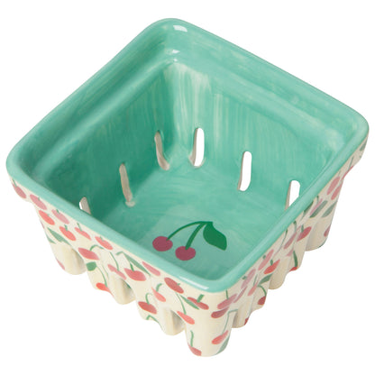 angled view of the cream berry basket with red cherries images on the outside of the basket and a cherry image in the center of the basket