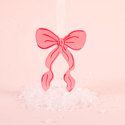 pink flat acrylic bow ornament shown on a pink background