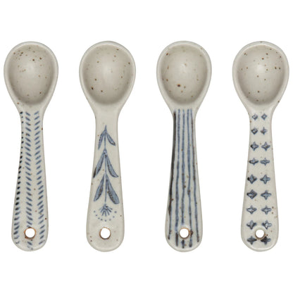 four ceramic spoons in a row on a white background