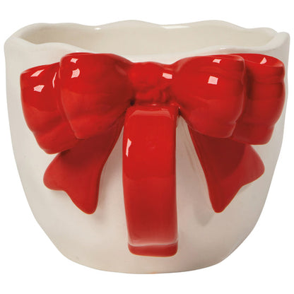 handle view of A white ceramic mug with a red sculpted bow tie on the handle
