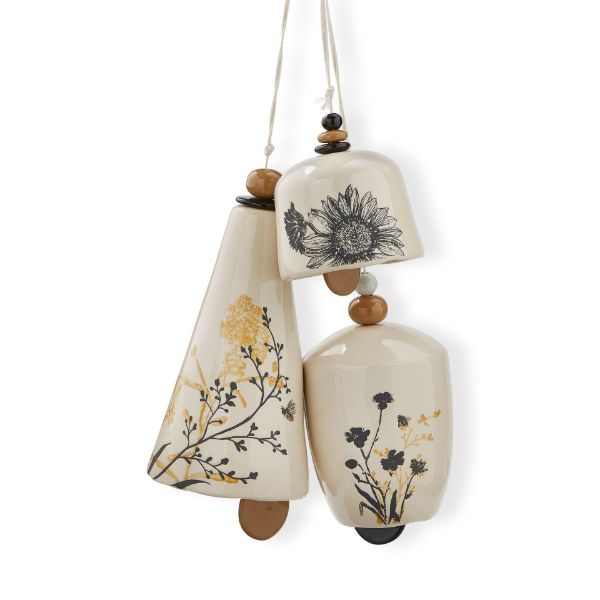 3 sizes of cream colored ceramic bell chimes with black and yellow floral designs hung on beaded twine.