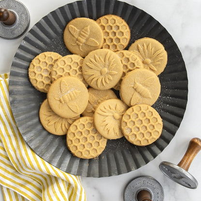 plate of cookies stamped with bee, flower, of honeycomb designs.