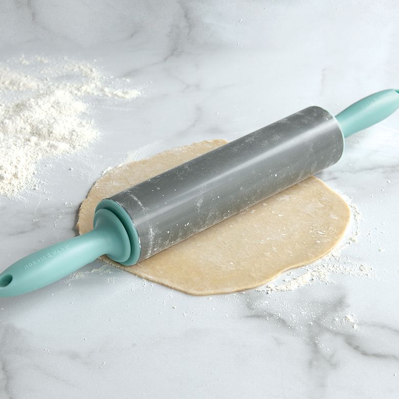 rolling pin on pastry dough on countertop.