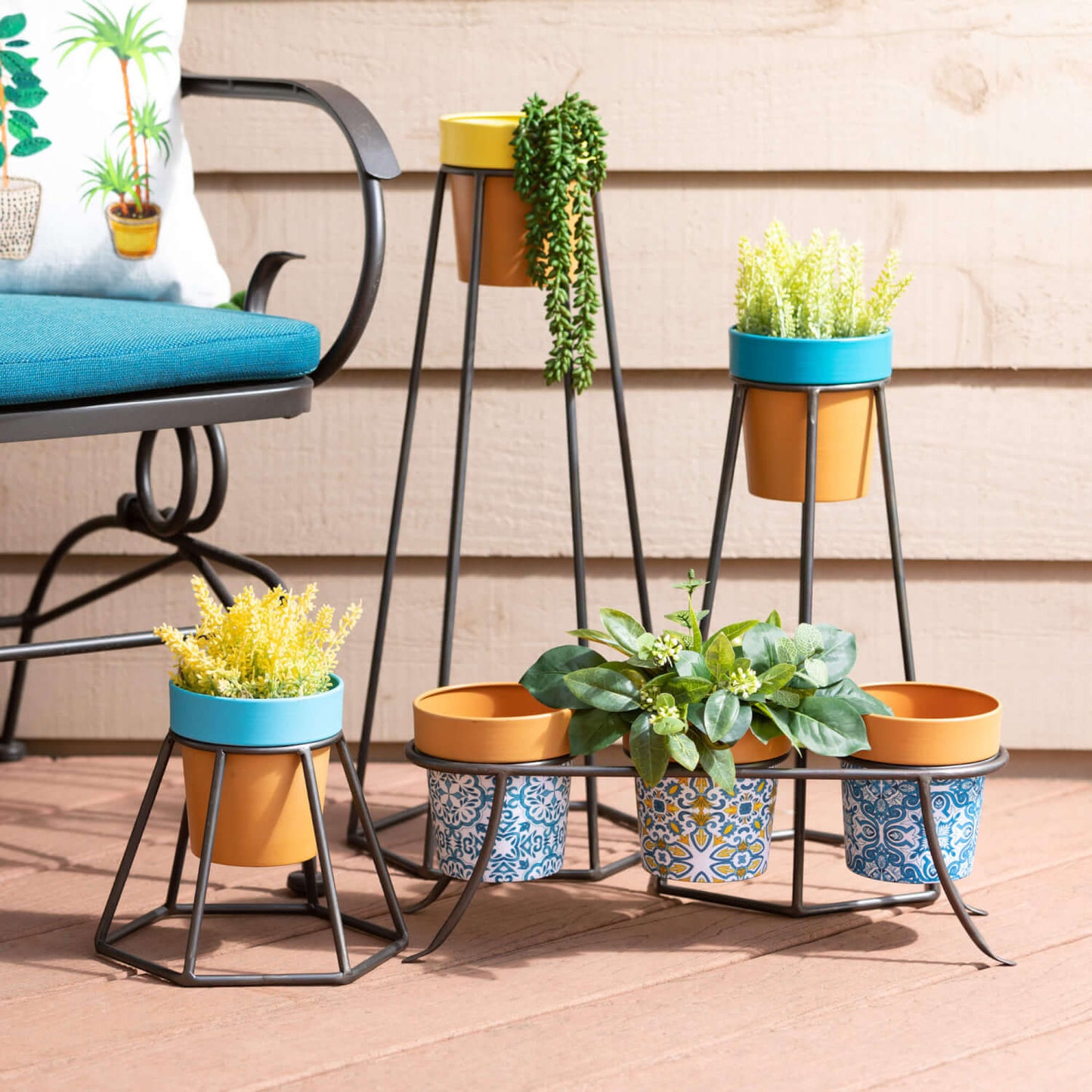 arrangement of colorful pots on plant stand and filled with a variety of greenery.