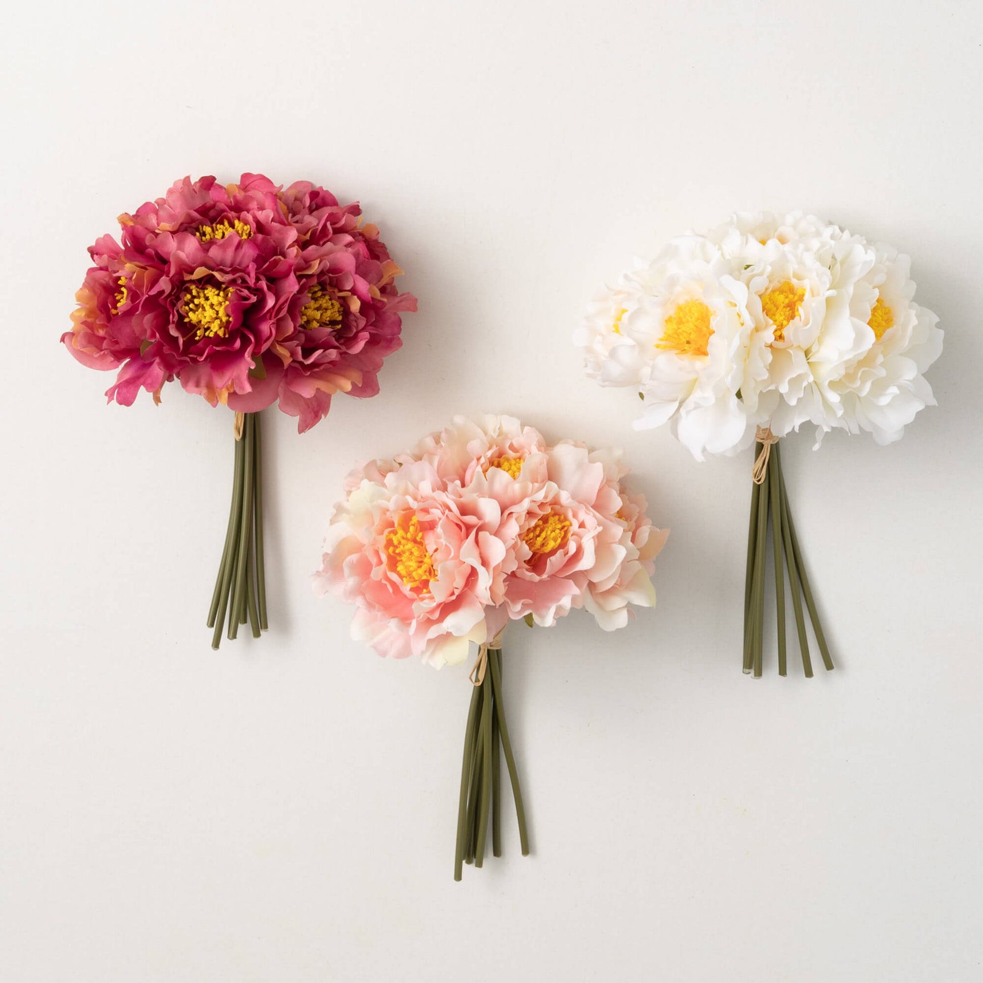3 bundles of artificial flowers in various shades of pinks.