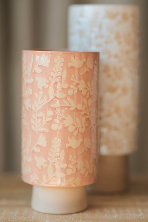 close-up of blush pink vase with taller vase in background.