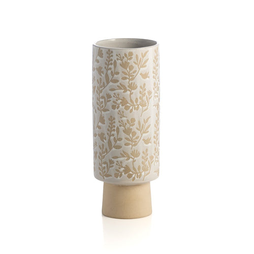 cylindrical vase with creamy white glaze and floral design on white background.