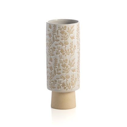 cylindrical vase with creamy white glaze and floral design on white background.