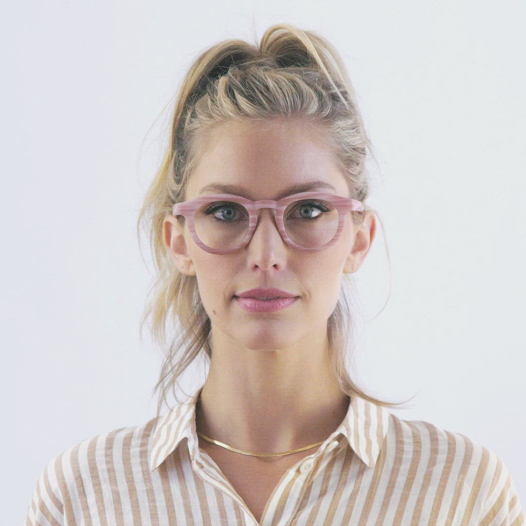 video of a woman modeling the pink horn stardust glasses and turning her head to show both sides against a white background