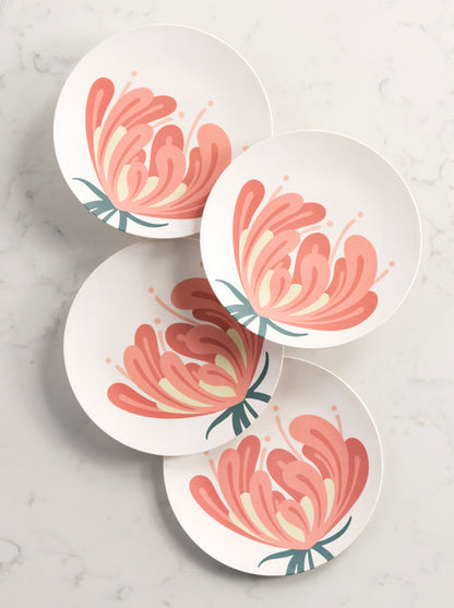 4 salad plates with floral pattern arranged on a  marble background.