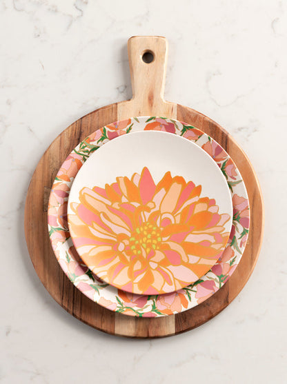 primavera multi floral appetizer plate displayed on floral dinner plate on a round wood paddle board displayed on a white marble surface