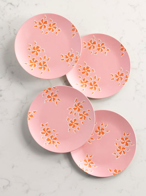4 pink and floral salad plates arranged on a marble background.