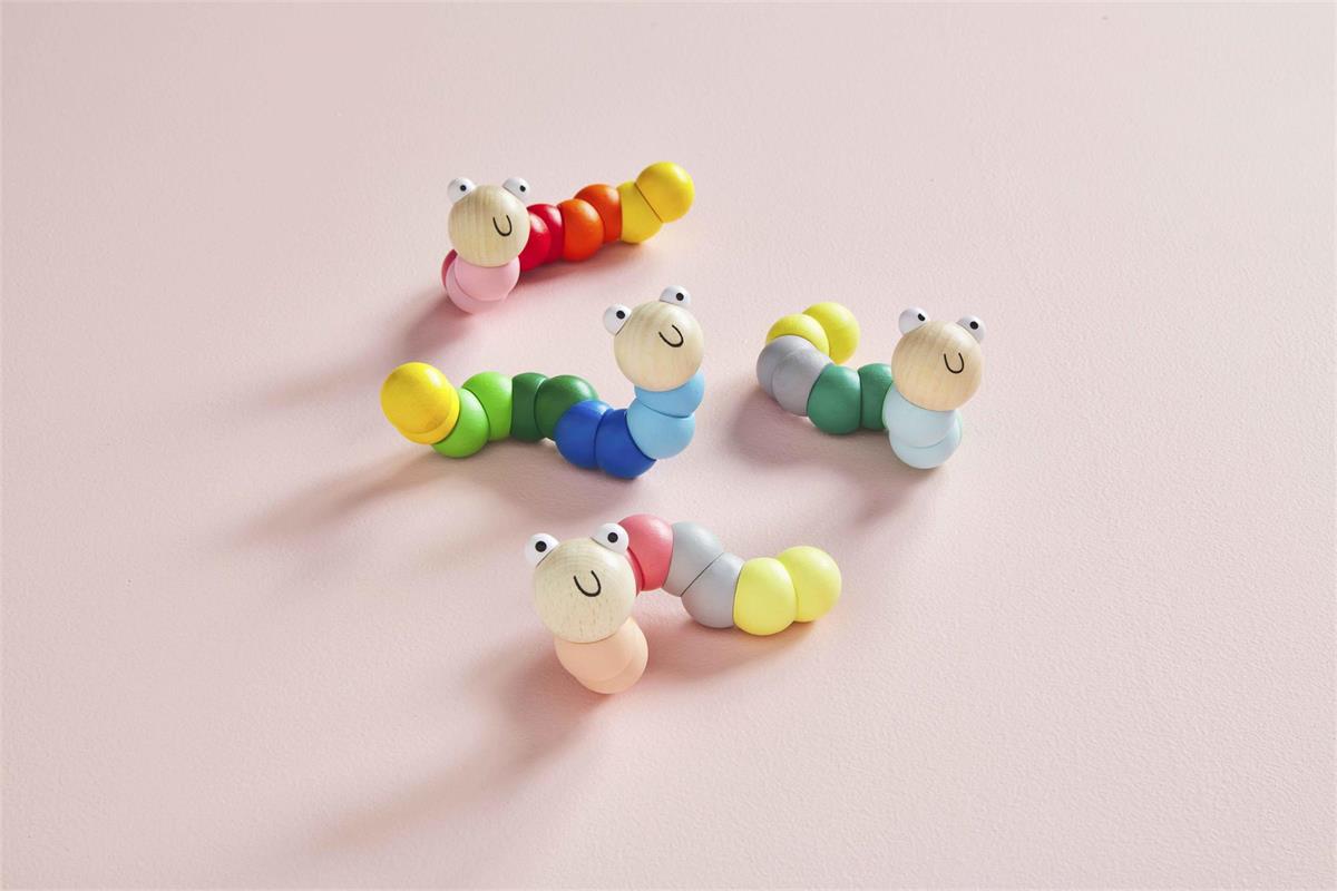 all four colors of wiggle worm toys displayed on a pink background