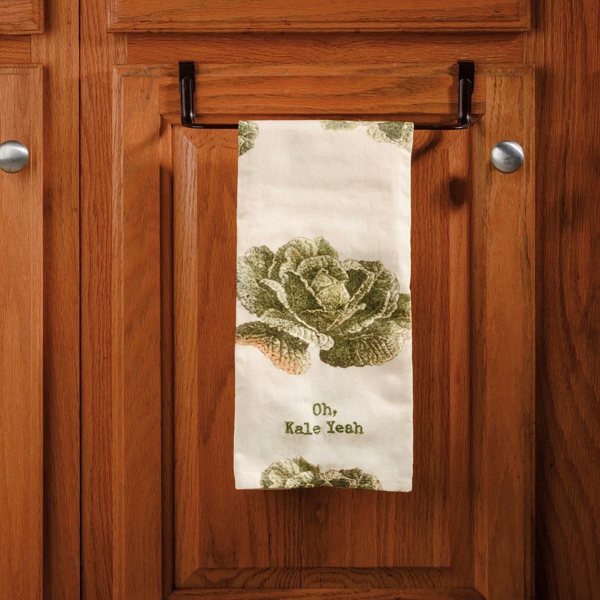 towel hanging on towel bar with kale graphics and "oh kale yeah" embroidered on the bottom.