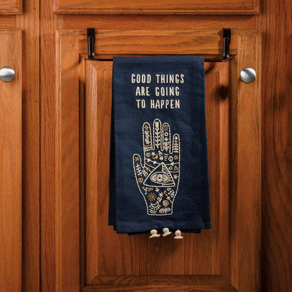 blue towel with hand design and sentiment hanging on a bar on kitchen cabinets.