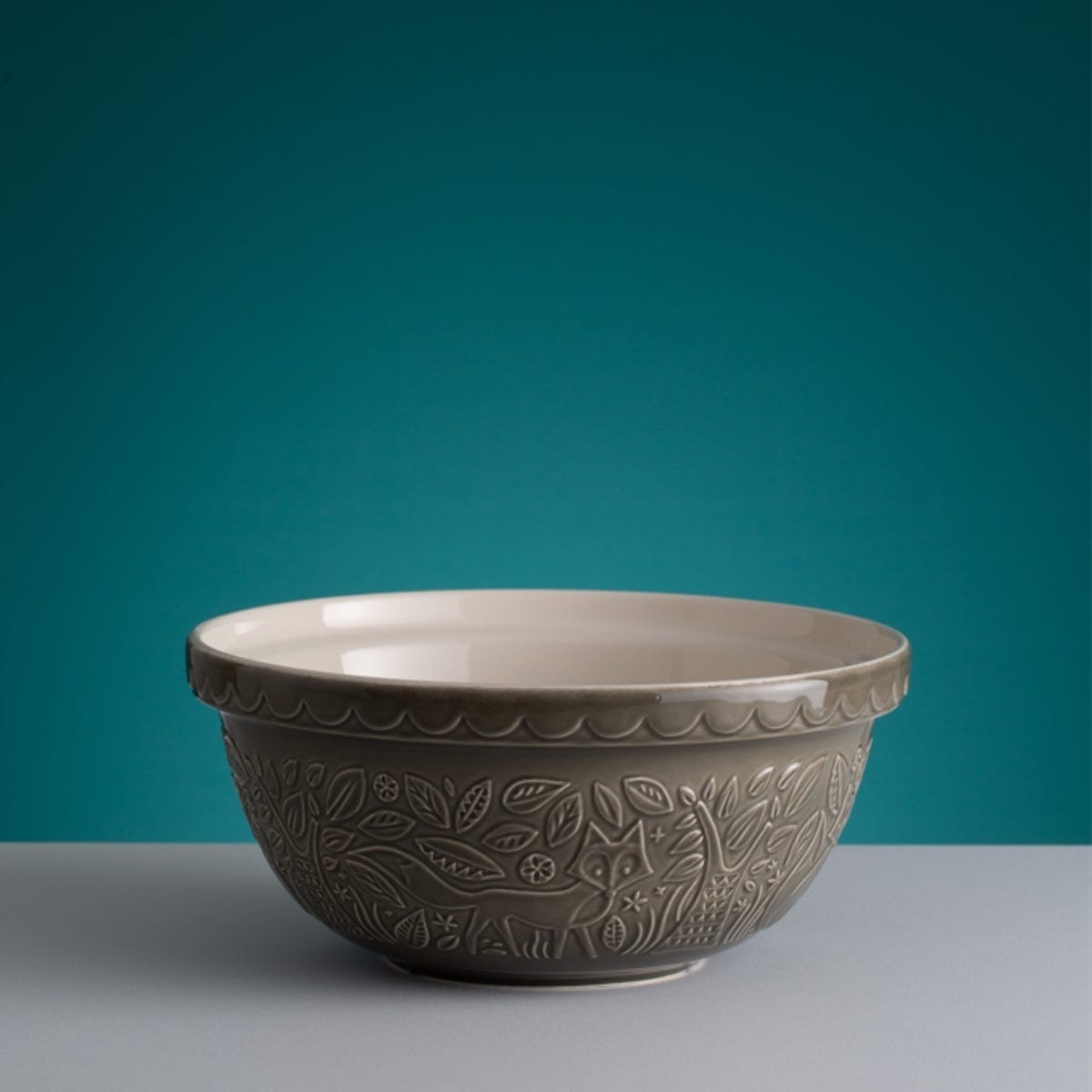 grey fox bowl on a table with a teal background.