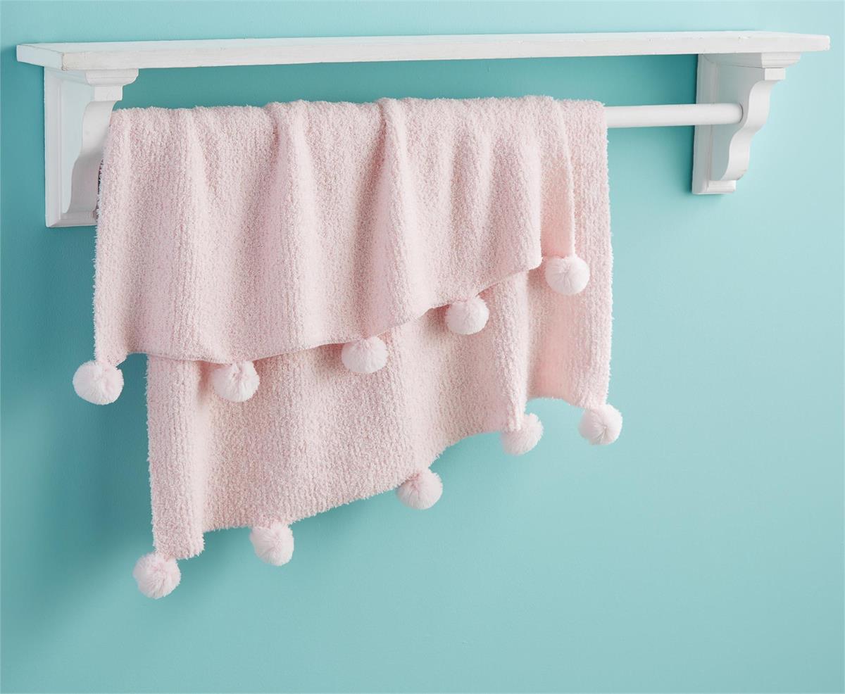 pink chenille blanket hanging on a quilt shelf against a turquoise wall