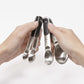 hands holding measuring spoons.
