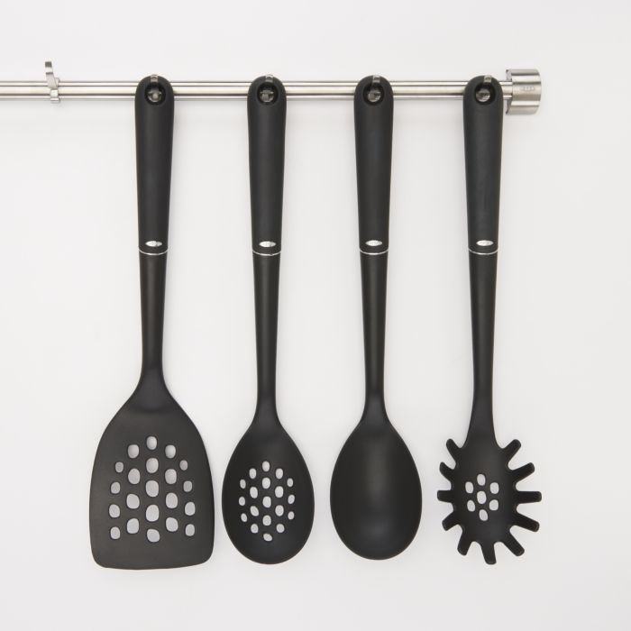 spatula, slotted spoon, spoon, and  pasta fork hanging on utensil bar.