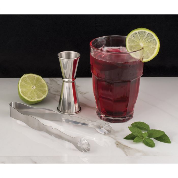 the stainless steel ice tongs displayed with a drink jigger cut lime and mint leaves on a white marble countertop against a black background