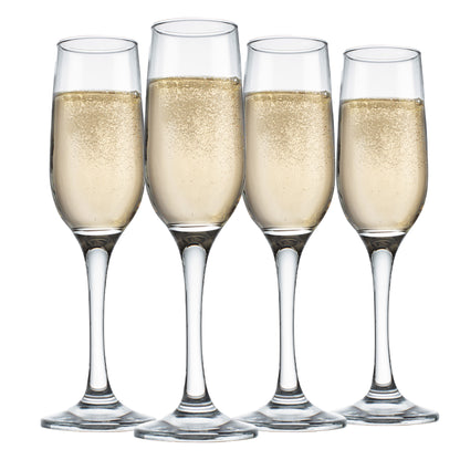 four champagne flutes filled with champagne against a white background