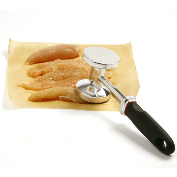 hammer on raw chicken on parchment paper.