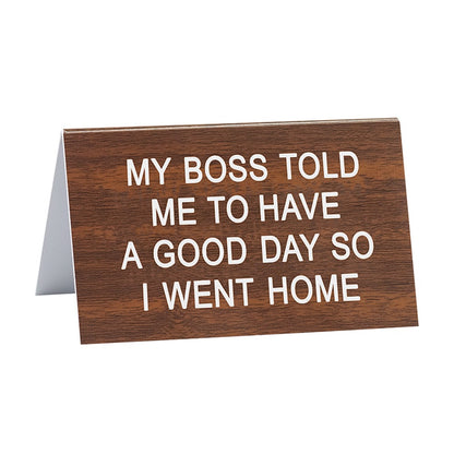 brown sign with sentiments "my boss told me to have a good day so I went home" on a white background