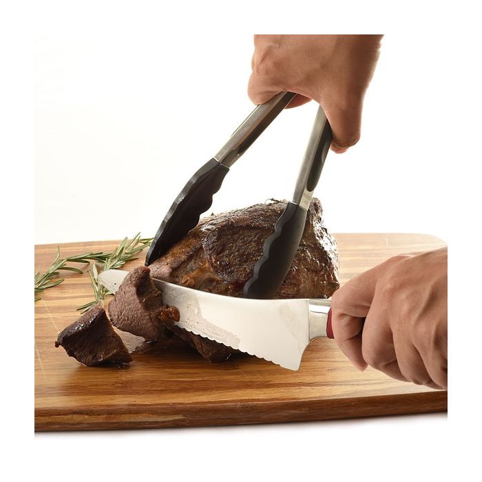 tongs holding meat being sliced.