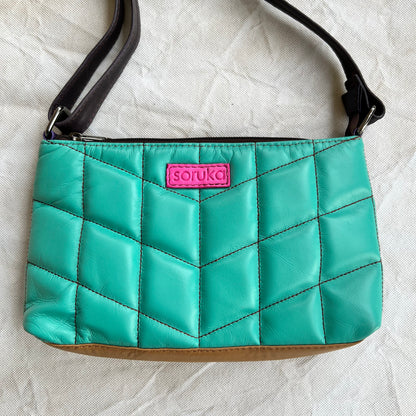 seafoam green puffy quilted leather purse with brown strap and pink "soruka" logo.