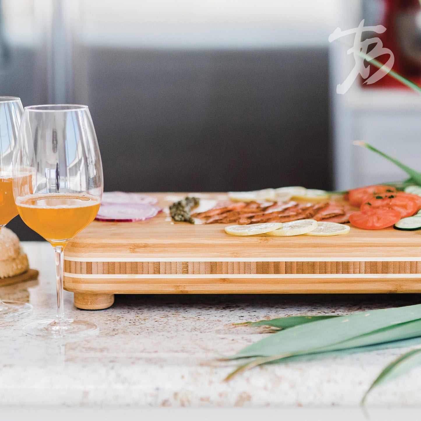 footed board on countertop arranged with appetizers and wine glasses set to the side.