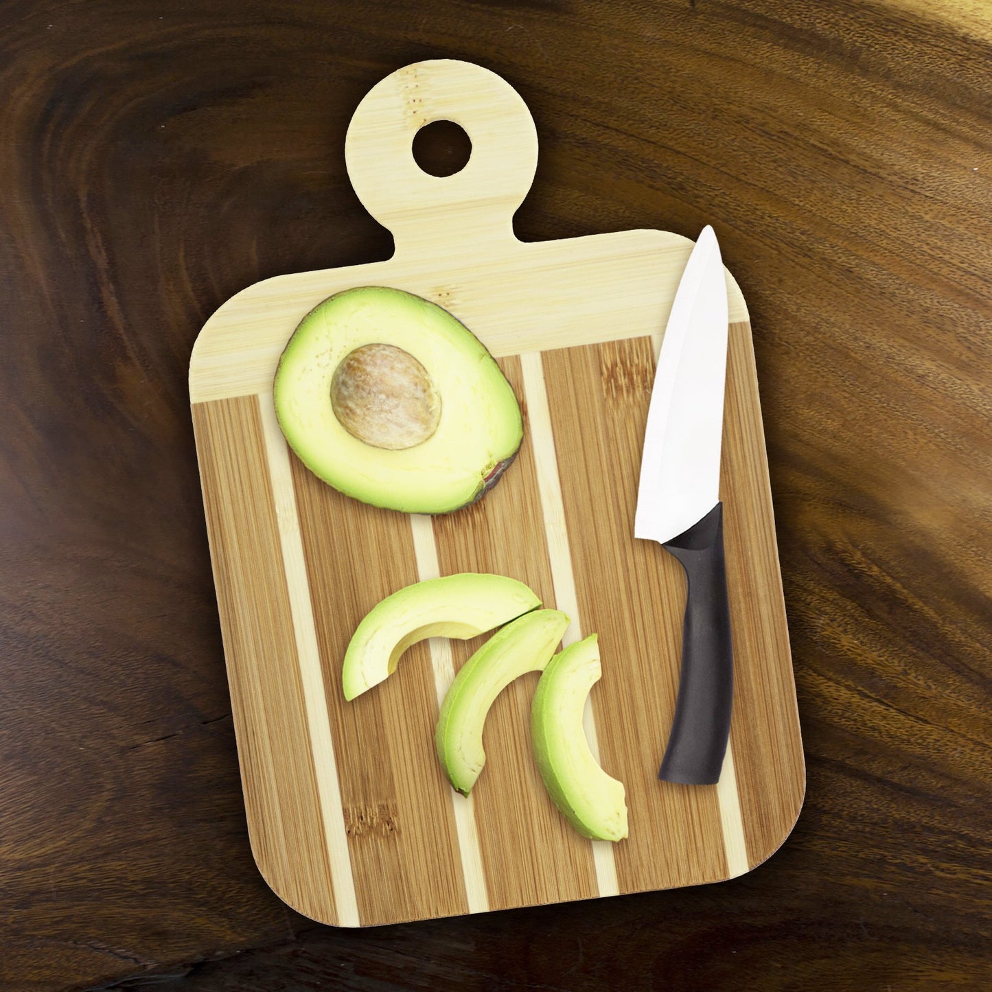 wood board with knife and sliced avocado on it.