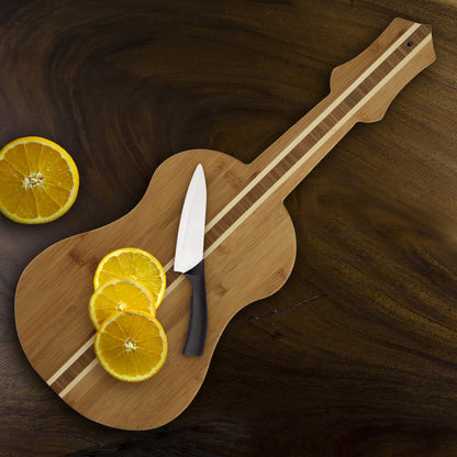 ukulele shaped board with knife and sliced lemon on it.