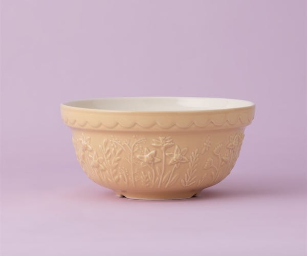 yellow bowl with floral design on a lavender background.