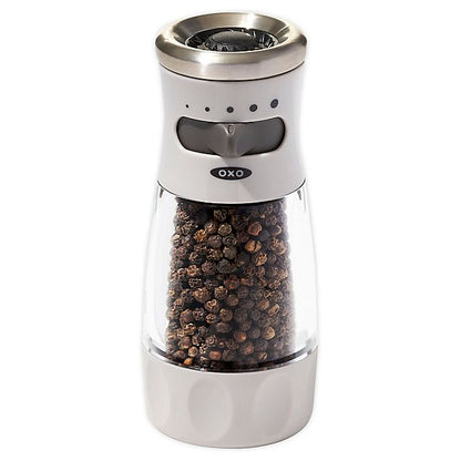 white and clear acrylic pepper grinder filled with pepper corns.