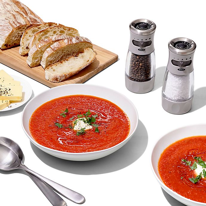 grinders, sliced bread, spoons, and bowls of tomato soup.