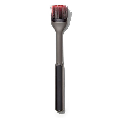 basting brush with black handle and grey and red bristles.