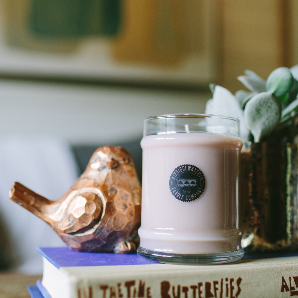 sweet grace candle displayed with books and bird decor