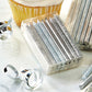 packages of silver and glittered candles on table with cupcake and confetti.