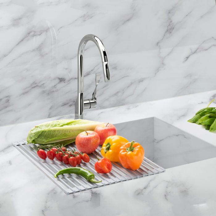 roll up dish drying rack displayed over a marble sink with fresh produce drying on itunrolled drying rack over a sink with fresh produce on it.