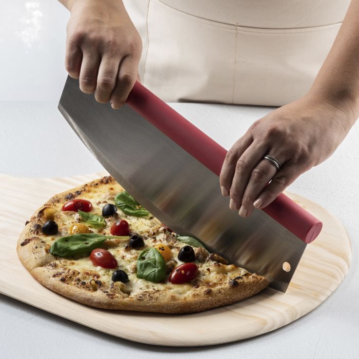 a person using the rocking pizza cutter on a pizza on a wooden pizza peel