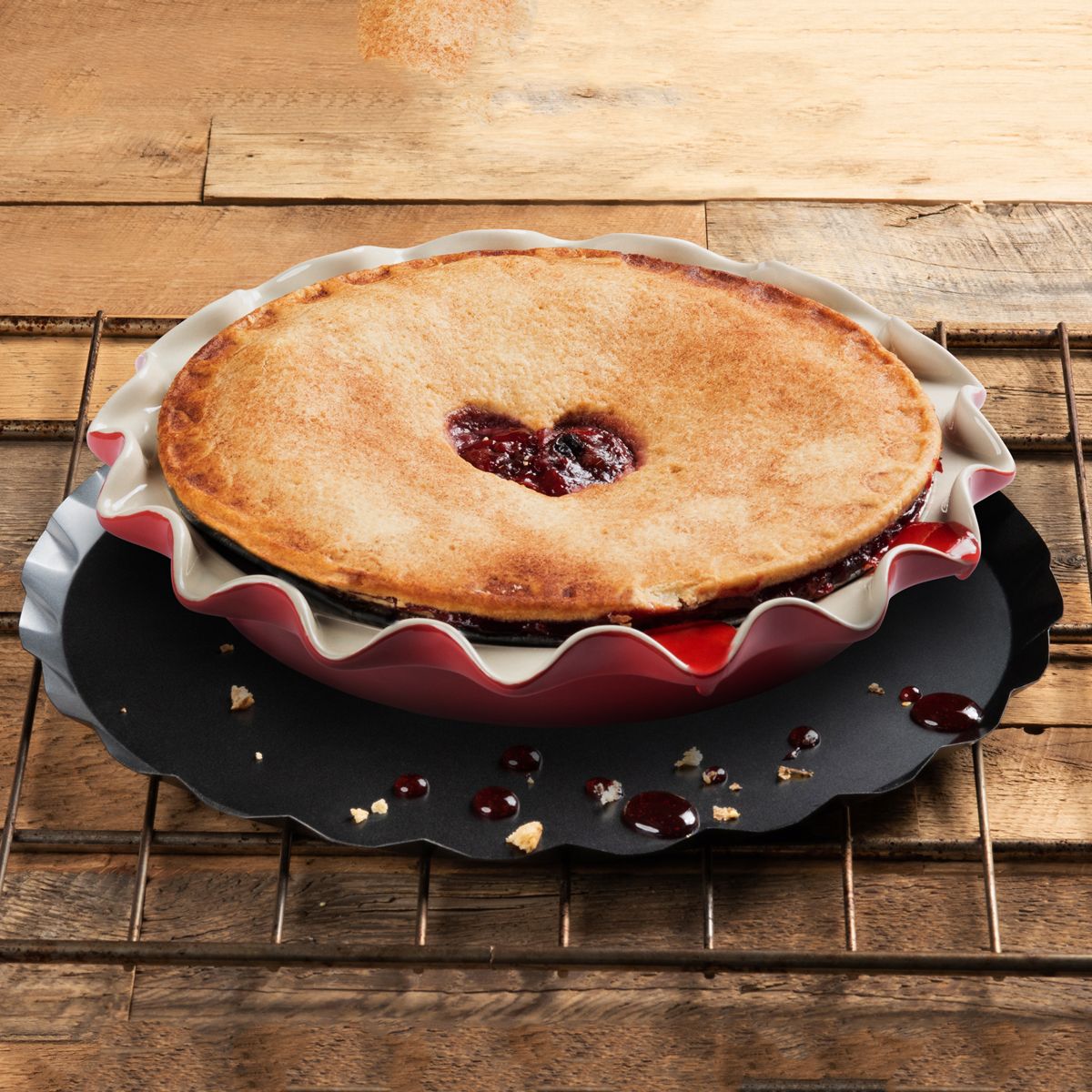baking pie drip catcher displayed on a rustic wood slat surface with a baked pie resting on top
