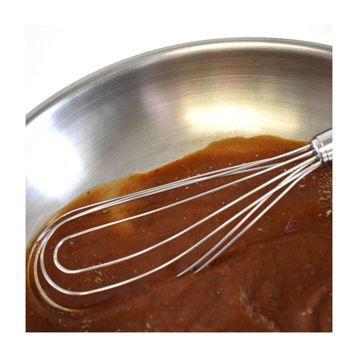 whisk in bowl filled with gravy.