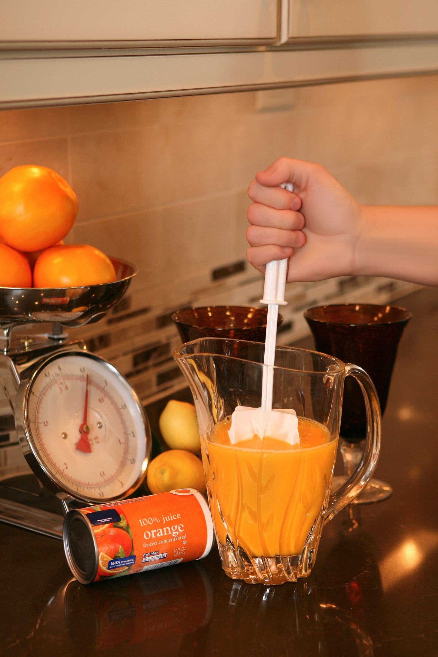 illustration of the white chopstir being used with a pitcher of frozen juice in a kitchen