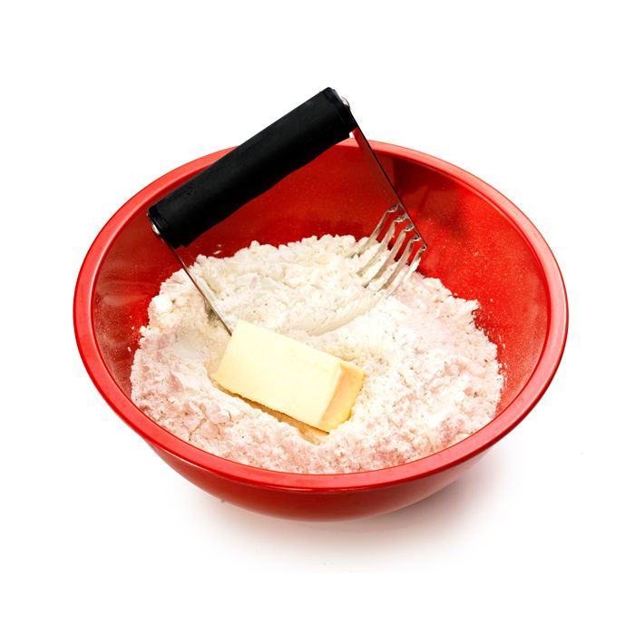 pastry blender in bowl filled with flour and stick of butter.