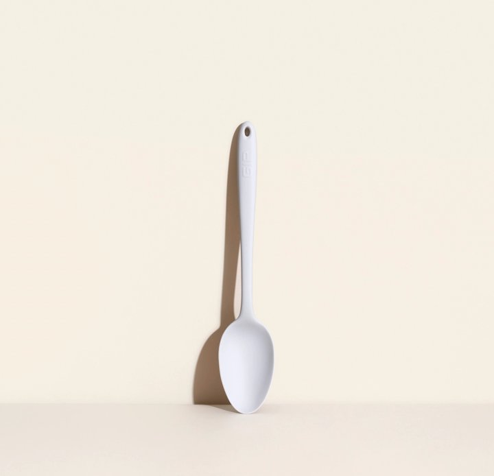 ultimate spoon leaning on a cream colored background.