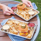 burger trays filled with burger, fries, and condiments on picnic table.
