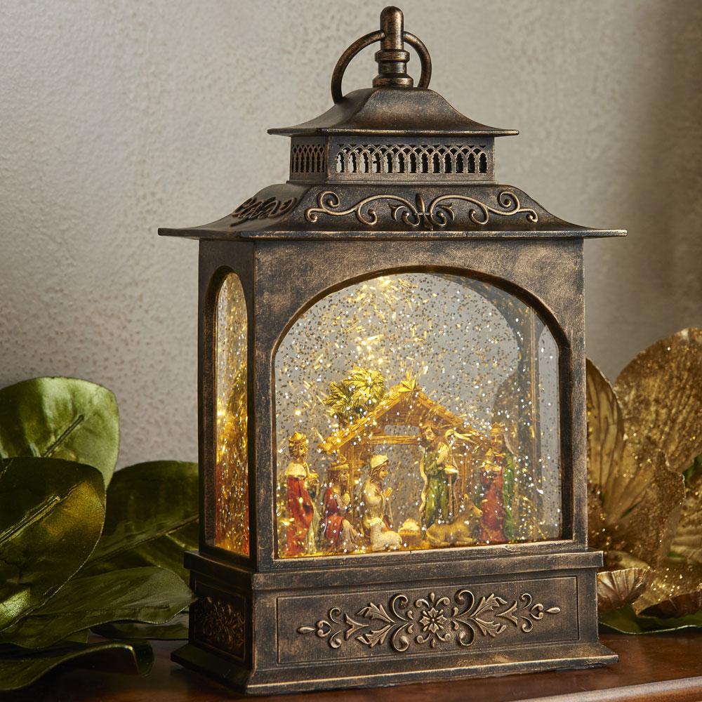 lit water lantern with glitter and nativity scene inside.