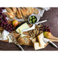 an array of cheeses, bread, and olives on a cutting board on a grey stone countertop.