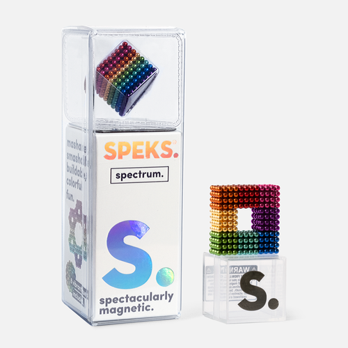 box packaging of specks with words "spectacularly magnetic" on it and a geometric shape made from rainbow colored magnetic balls on a small acrylic stand on a white background.